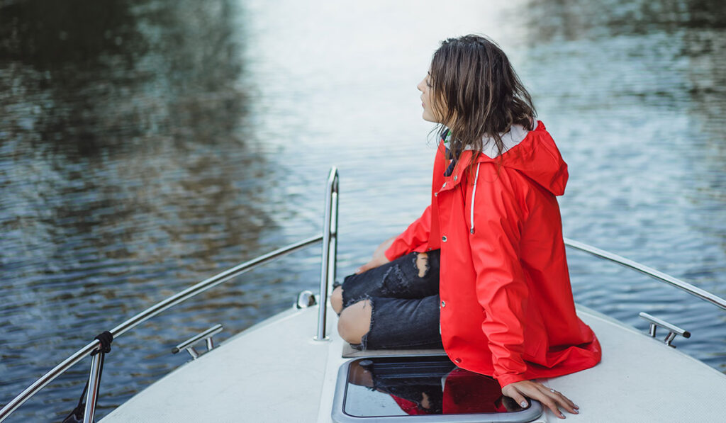 Dziewczyna w czerwonej kurtce na łódce